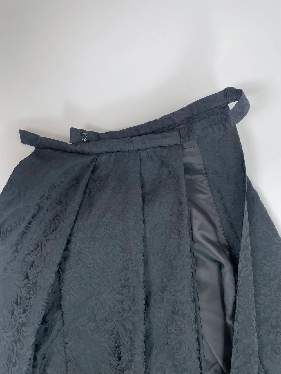 Self waistband with centre-back extension, hooks and deep pleats
